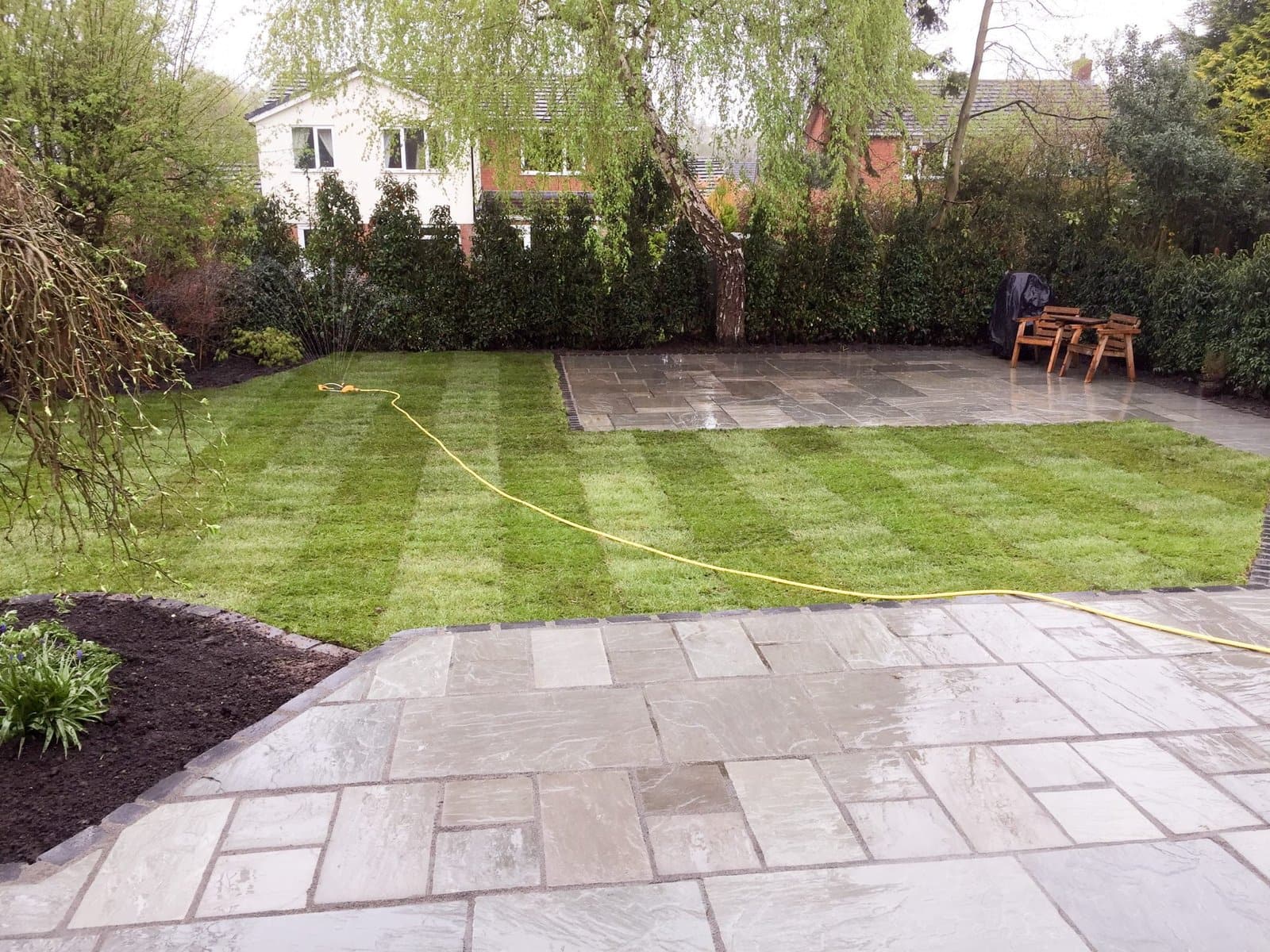 Contemporary garden with new patio, striped lawn and fresh boundary fencing in Holmes Chapel