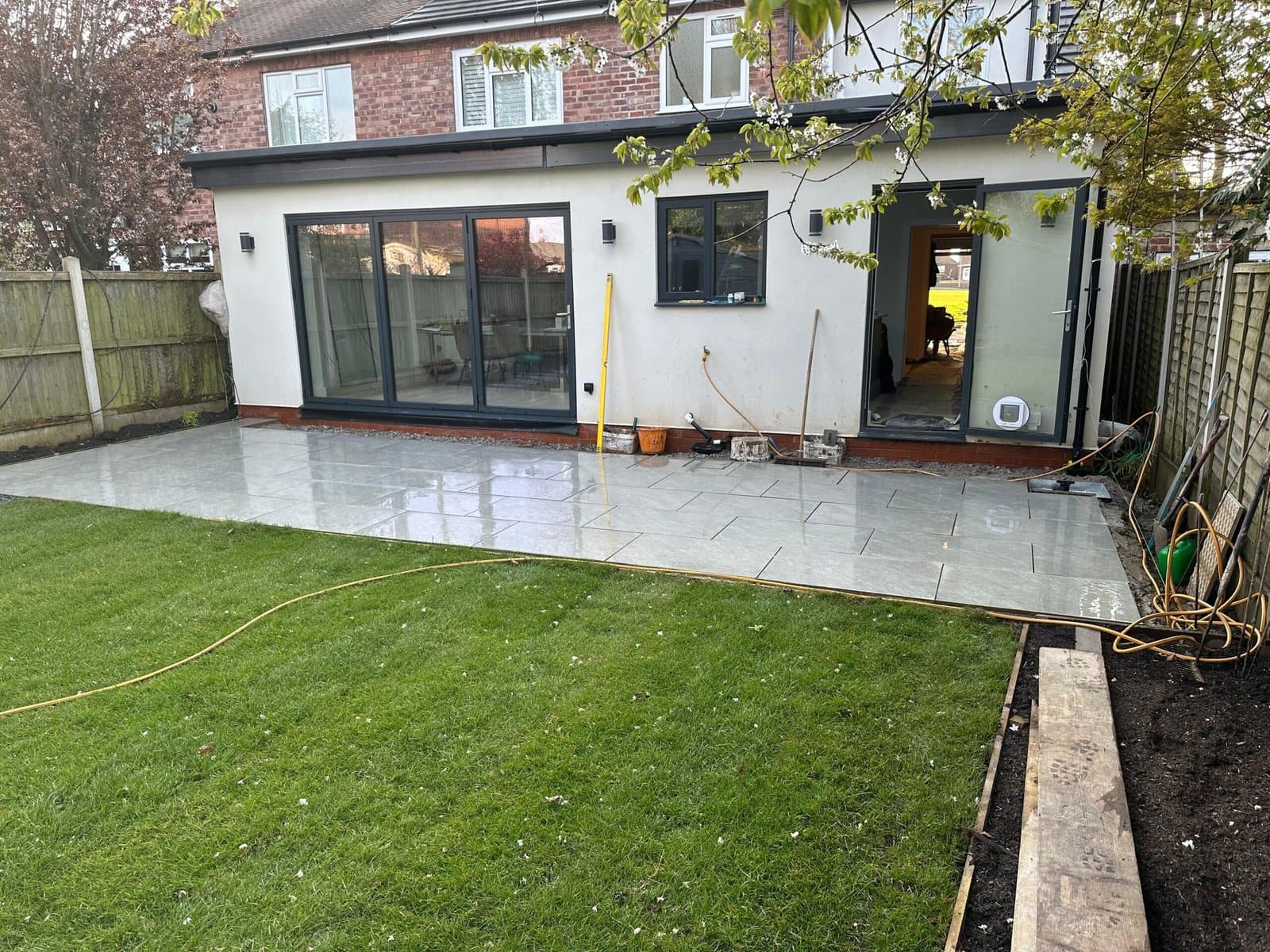 Large-format porcelain patio and fresh turf in a contemporary Cheshire garden