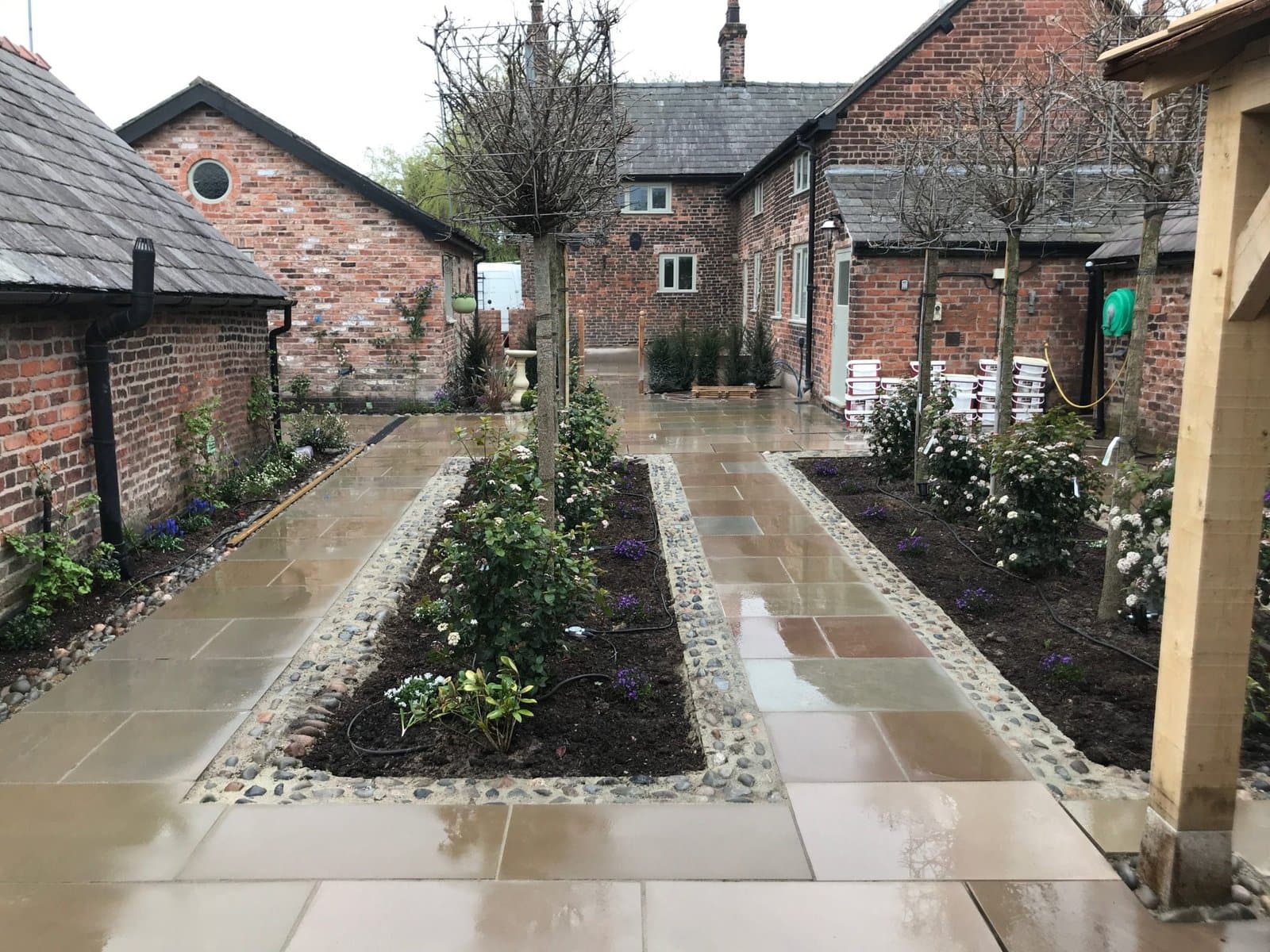 Sandstone pathways and cobble-edged planting beds at a period Cheshire property